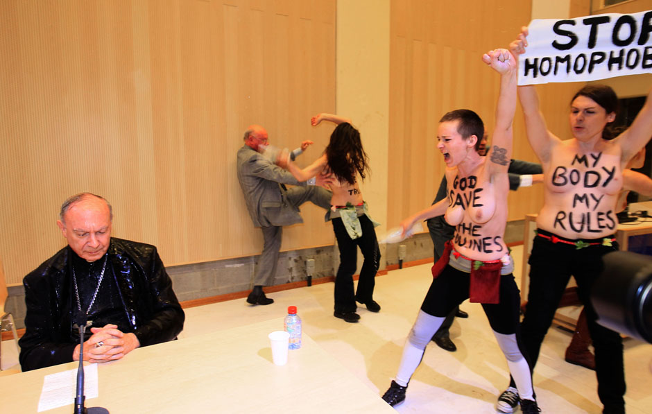 Activists from women's rights group Femen spraying water at Belgian Archbishop of Mechelen-Brussels and Primate of Belgium Leonard during a conference at Brussels university ULB