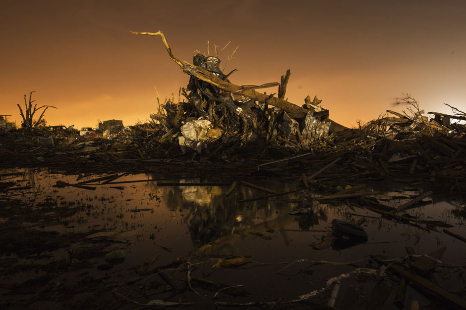 A car rests on top of a pile of debris in an area heavily damaged by a tornado in Moore, Oklahoma