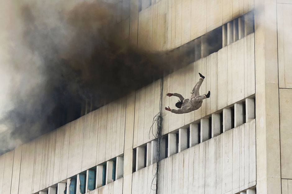A man falls from a high floor of a burning building in central Lahore