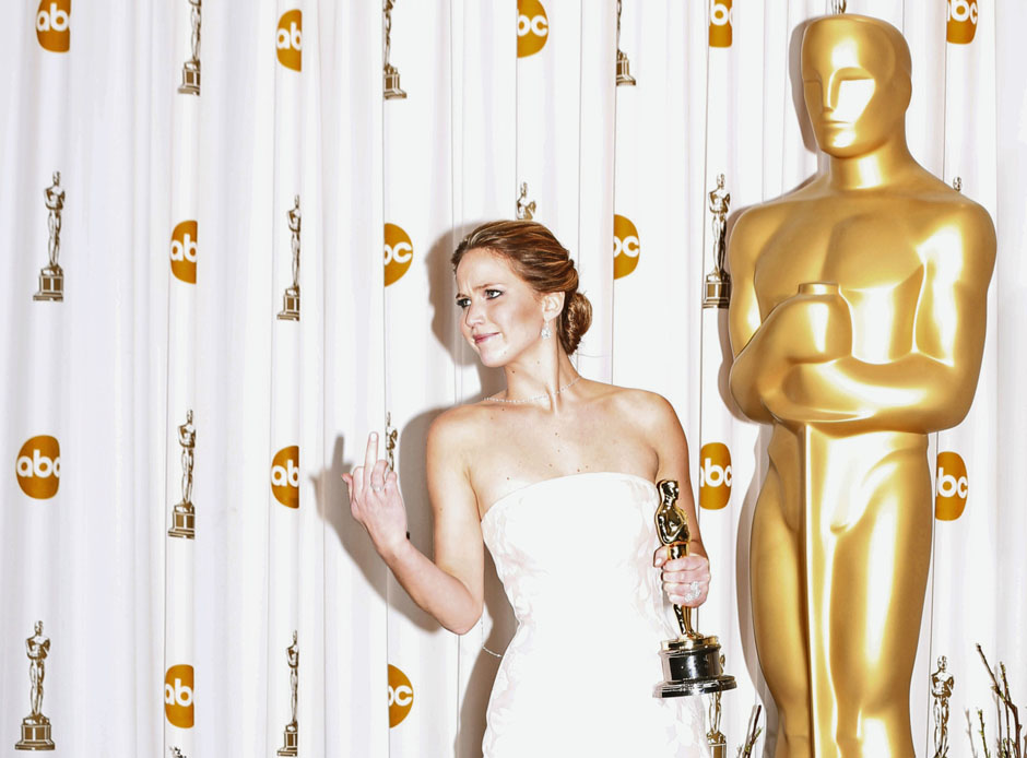 Jennifer Lawrence reacts as she poses with her Oscar after winning the Best Actress award for her role in 