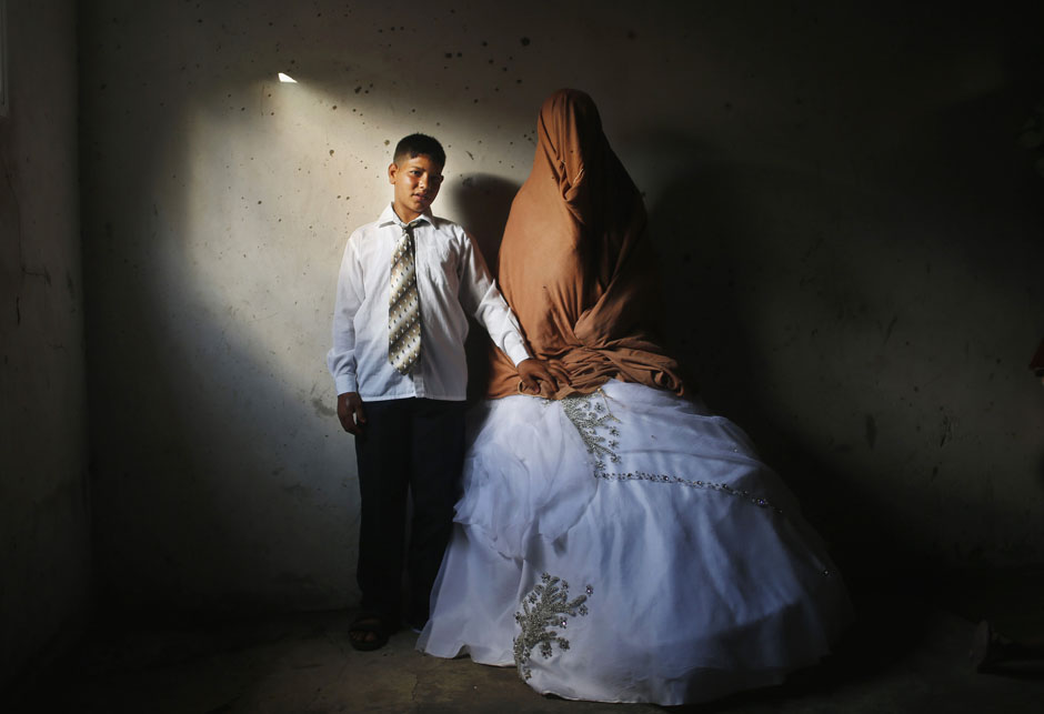 Palestinian groom Ahmed Soboh and his bride Tala stand inside Tala's house which damaged during Israeli strike in 2009, during wedding party in Beit Lahiya