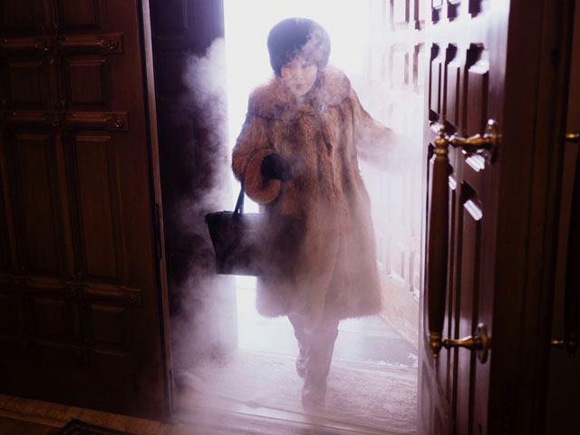 A local woman enters Preobrazhensky Cathedral in a swirl of freezing mist.