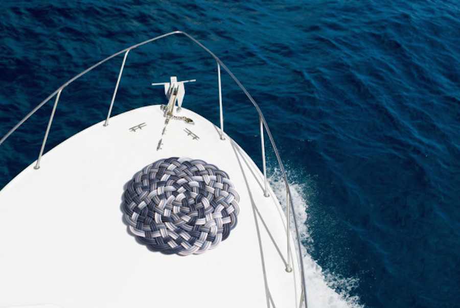 bikini woman sunbathing on the bow of a luxury yacht