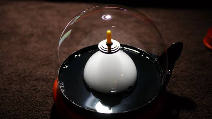 Spinning Floating Top inside a Smoke-Filled Bubble