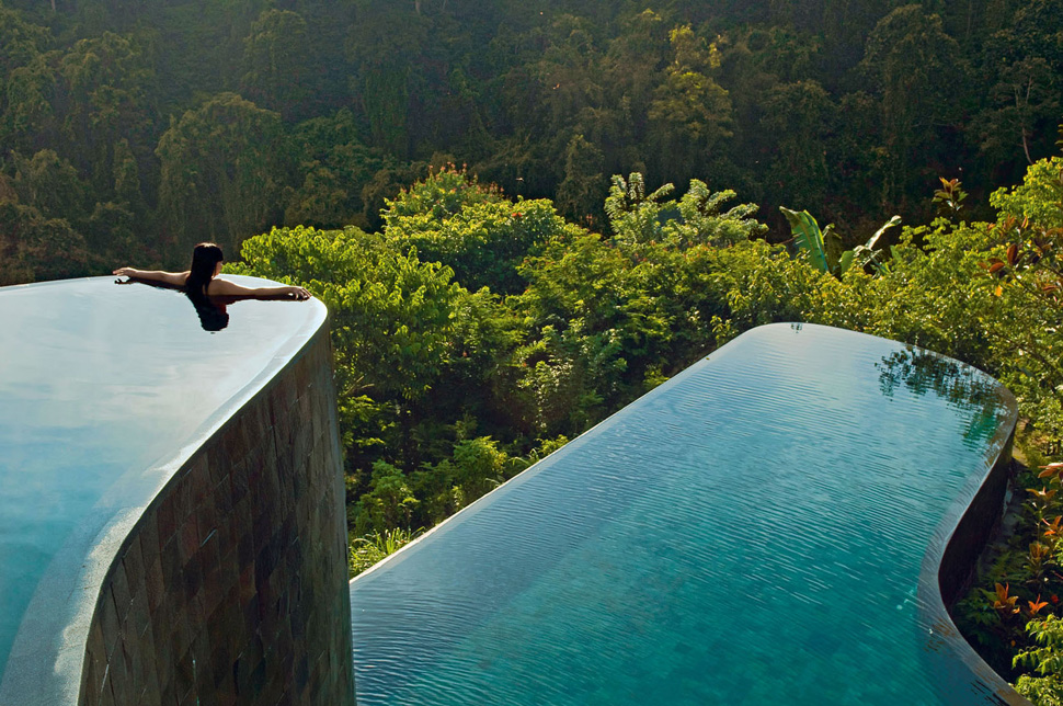 Indonesia, Bali, Gianyar, Buahan Payangan, Ubud Hanging Gardens hotel group Orient-Express, one young woman back outstretched arms, infinity pool overlooking the jungle at sunrise