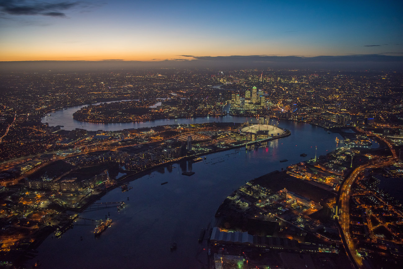 2300ft over Greenwich Peninsula at night. The O2 lit up on the peninsula and Canary Wharf and the City of London in the distance. Peninsula Place a new development on the site, will form part of an £8.4bn revamp opposite the financial district of Canary Wharf. It is part of the largest regeneration project by a developer in the UK.