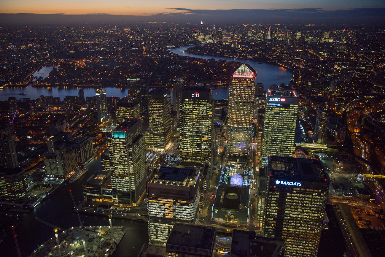 The huge business and banking district of east London, Canary Wharf. Located on the West India Docks on the Isle of Dogs. This view shows the towers of Canary Wharf, looking West with the River Thames snaking to Westminster.