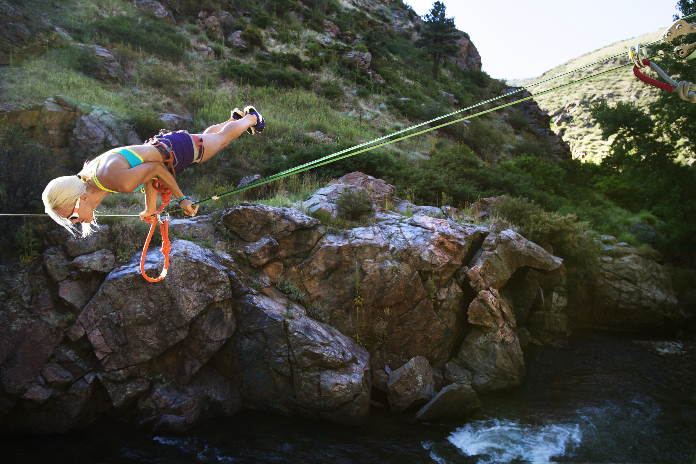 Woman balancing on rope while slacklining over river