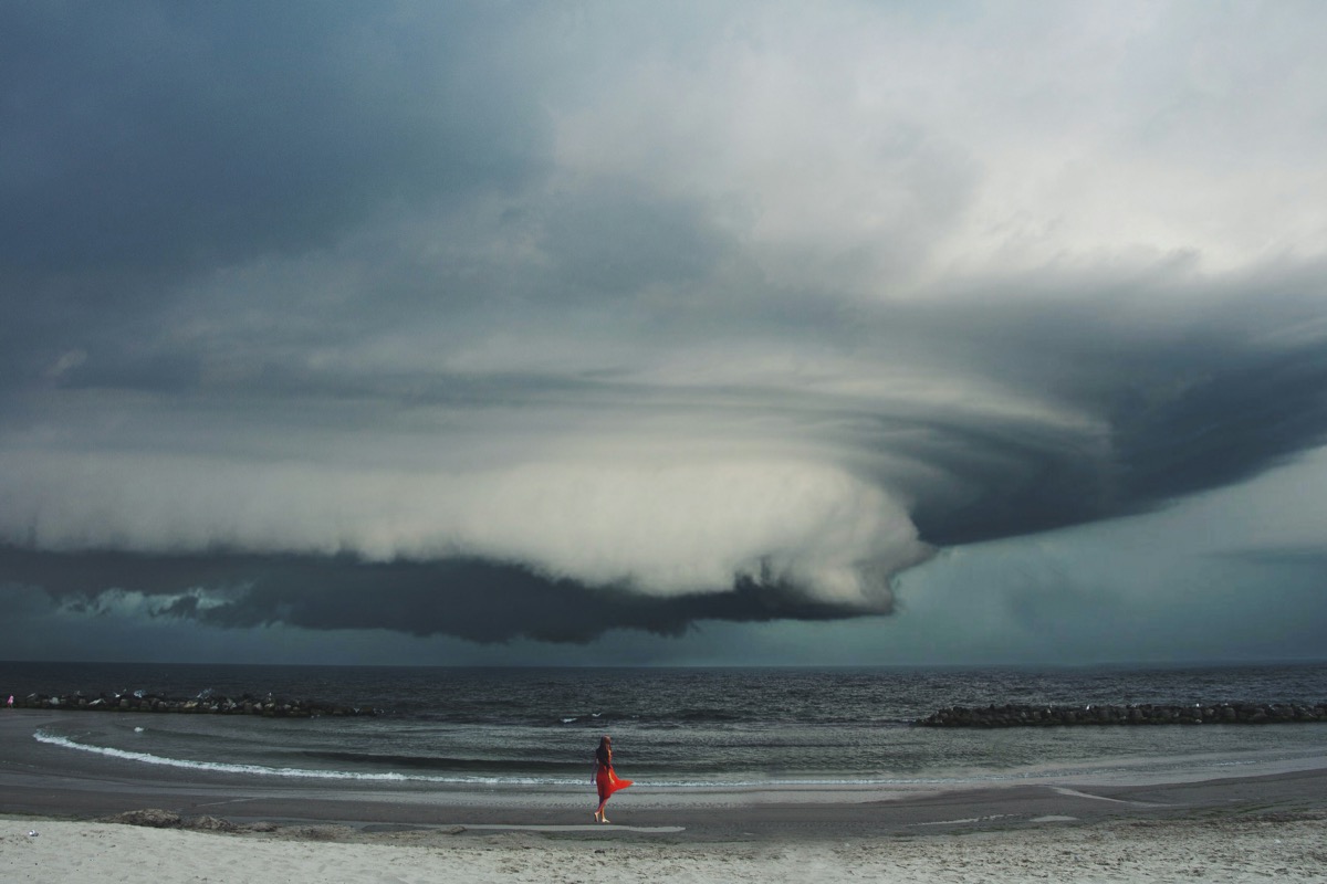 Woman Standing On Shore During Stormy Weather