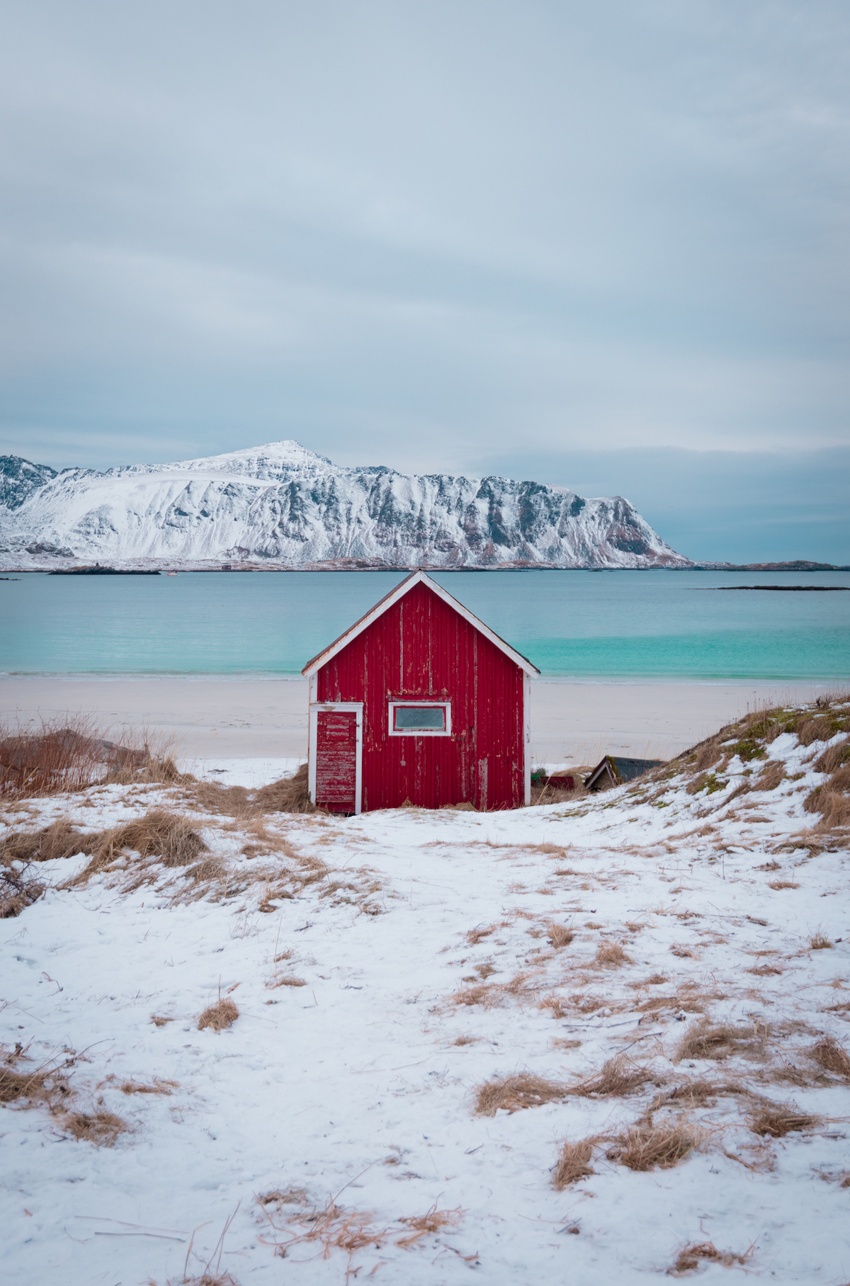 Red cabin on snowy shore